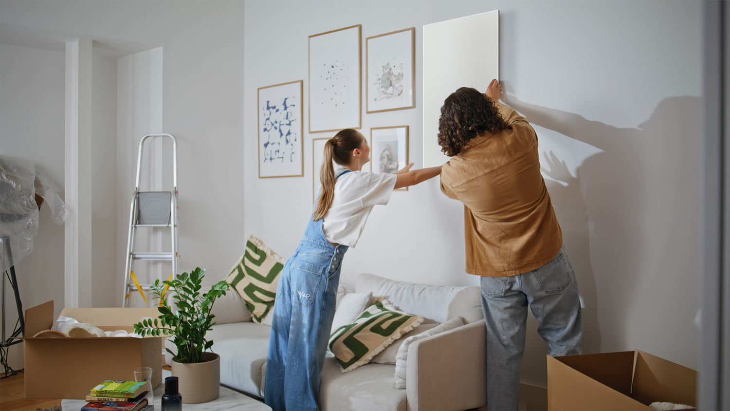 Junges Paar hängt gemeinsam ein Infraredly Infrarotpaneel an die Wand